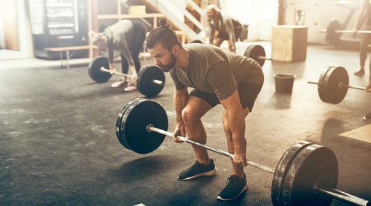 Best Adaptogens for Athletes. Three athletes performing deadlifts in the gym.