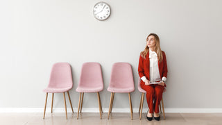 Woman sin red suit sat outside an office waiting for her job interview. Best Nootropics for Job Interviews in 2025
