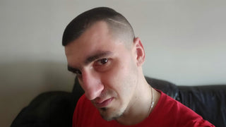 A side profile picture of a man with short dark hair and a red t-shirt