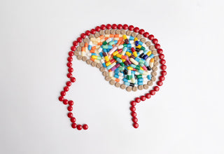 Homemade Nootropics: Building the Best Stack. A head and brain profile made with multicolored nootropic capsules.