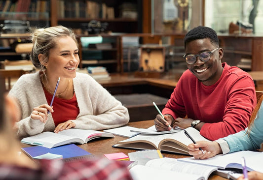 Happy students after taking nootropic supplements, studying in the library