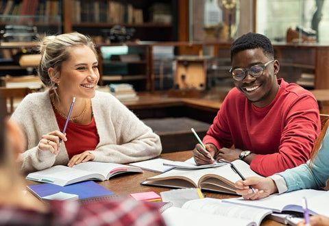 Happy students after taking nootropic supplements, studying in the library