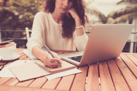 Best Nootropics for Writers in 2025. A woman sits outside writing on a laptop.