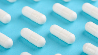 Best multivitamins. White capsules on blue background.