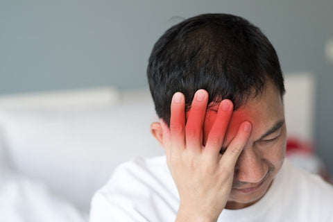 Best Nootropic Supplements for Concussion. A man holds his aching head.