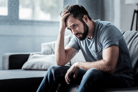 Best Nootropics for Depression in 2025. A sad man sits holding his head in his hand.