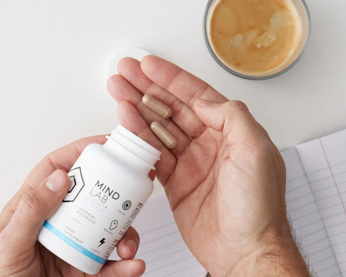 image of a main holding Mind Lab Pro® whilst eating breakfast and drinking a coffee